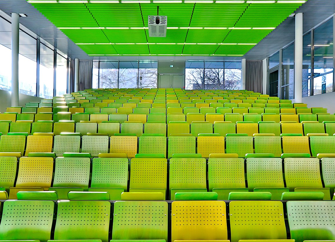 Hörsaal mit grünen Stuhlreihen